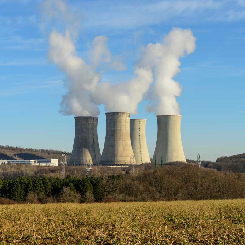 Nuclear Power Plant towers with smoke rising out of them. 
