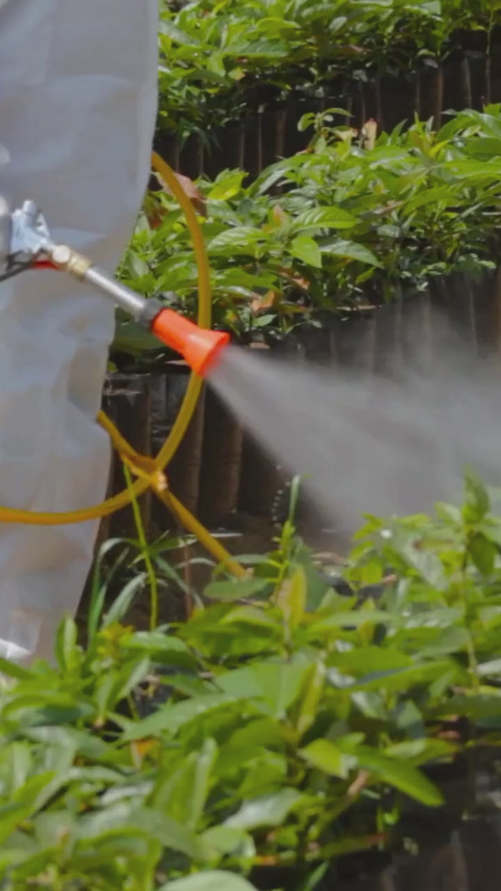 Worker spraying a fertilizer made with Phosphoric Acid onto plants.
